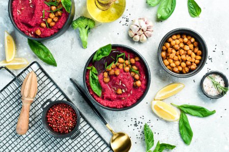 Photo for Red hummus from beets and chickpeas in a bowl. Vegan recipes based on plant foods. On a concrete background. - Royalty Free Image