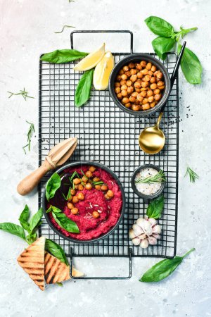 Téléchargez les photos : Hummus rouge de betteraves et pois chiches dans un bol. Recettes végétaliennes à base d'aliments végétaux. Sur un fond concret. - en image libre de droit