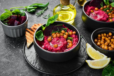 Photo for Healthy vegetarian food: Hummus. Beet and chickpea hummus in a bowl. On a concrete black background. - Royalty Free Image