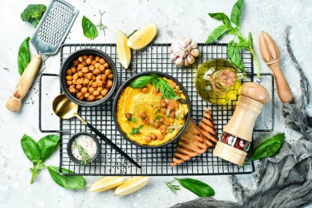 Photo for Hummus from chickpeas and pumpkin and carrots, with olive oil and spices. Healthy vegetarian food. On a concrete background. - Royalty Free Image