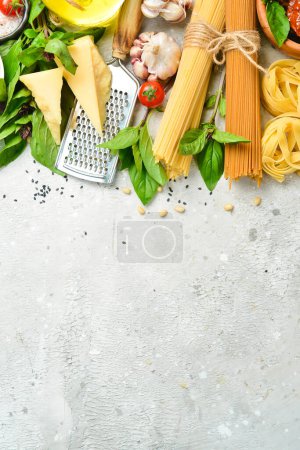 Téléchargez les photos : Bannière alimentaire. Cuisine traditionnelle italienne : sauce pesto, pâtes, basilic, parmesan et noix, huile d'olive. Sur un fond concret. Vue du dessus. - en image libre de droit