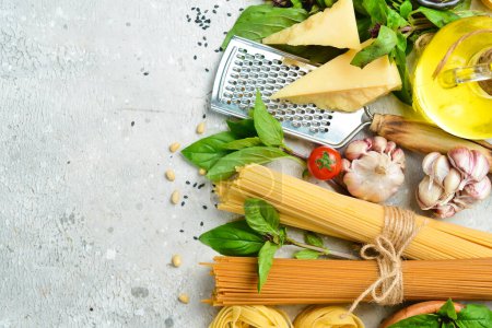 Photo for Food banner. Italian traditional cuisine: pesto sauce, pasta, basil, parmesan and nuts, olive oil. On a concrete background. Top view. - Royalty Free Image