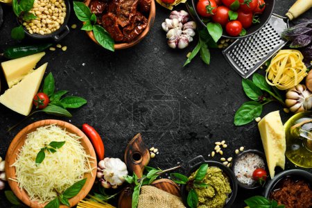 Photo for Kitchen banner with ingredients for cooking: pasta, cheese, greens, vegetables and spices. On a black stone background background. - Royalty Free Image