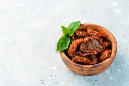 Photo for Sun-dried tomatoes in a wooden bowl. On a concrete background. - Royalty Free Image