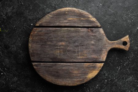 Téléchargez les photos : Cuisine planche en bois sur un fond de pierre noire. Vue du dessus. - en image libre de droit