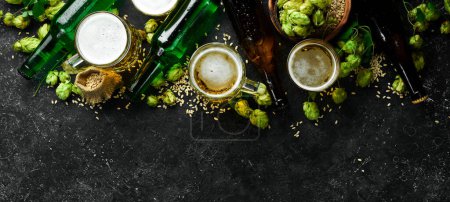 Foto de Banner de cerveza. Una colección de cerveza alcohólica en botellas y vasos sobre un fondo de piedra negra. - Imagen libre de derechos