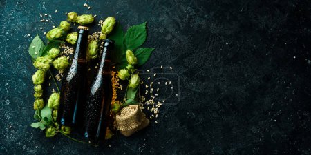 Photo for Fresh hop, glasses and beer. Dark beer in glass bottles on a black stone background. Beer banner. - Royalty Free Image