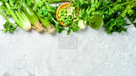 Photo for Green celery stalk and celery juice on gray stone background. Vegetarian drink. Free space for text. - Royalty Free Image