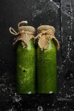 Photo for Green vegetable and fruit smoothie with kiwi, spinach, apple and celery in a bottle. Vegan food. Free space for text. - Royalty Free Image