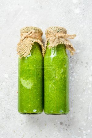 Photo for Green vegetable and fruit juice with kiwi, spinach, apple and celery in a bottle. Vegan food. Free space for text. - Royalty Free Image