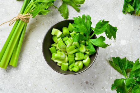 Photo for Celery stalk cut into pieces in a bowl. Vegan food. Free space for text. - Royalty Free Image