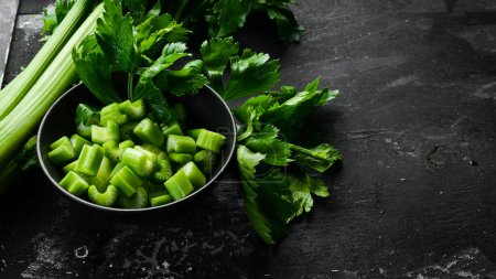 Photo for A stalk of fresh celery cut into pieces in a bowl. Dietary healthy food. Free space for text. - Royalty Free Image