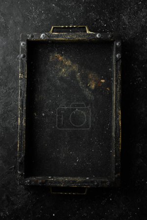 Foto de Caja negra de madera para alimentos o verduras sobre un fondo de piedra. Vista superior. Espacio libre para texto. - Imagen libre de derechos
