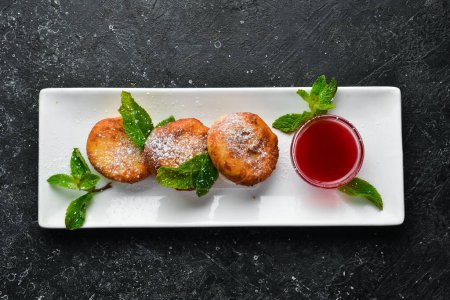 Photo for Dessert. Cheese pancakes with raspberry sauce and powdered sugar. On a black stone background. - Royalty Free Image