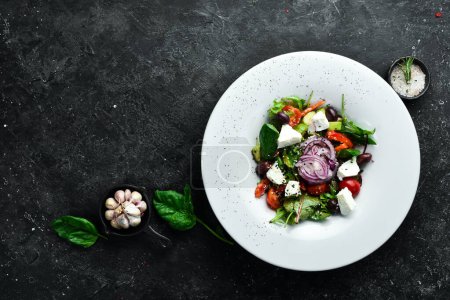 Photo for Traditional Greek salad with vegetables. On a black stone background. - Royalty Free Image