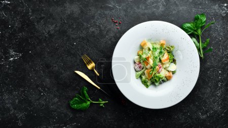 Photo for Traditional Caesar salad with chicken. On a black stone background. - Royalty Free Image
