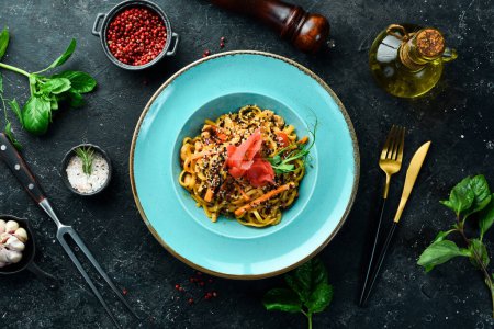 Photo for Vegan pasta with tomatoes, celery and ginger. On a black stone background. - Royalty Free Image