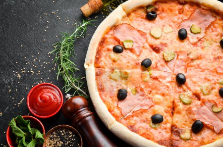 Foto de Pizza con tocino, pepino y aceitunas. Entrega de comida. Espacio libre para texto. - Imagen libre de derechos