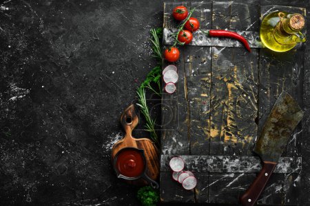 Foto de Fondo de cocina negro: verduras, especias y utensilios de cocina. Espacio libre para texto. - Imagen libre de derechos