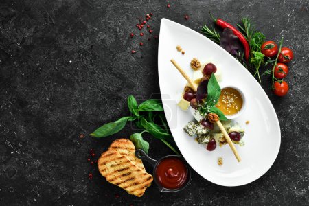 Photo for Antipasto Assorted cheeses: brie, parmesan, feta and blue cheese on a plate. Top view. Free space for text. - Royalty Free Image