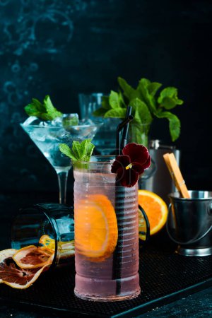 Foto de Limonada con jarabe de rosa y naranja. Sobre un fondo negro. Menú bar. - Imagen libre de derechos