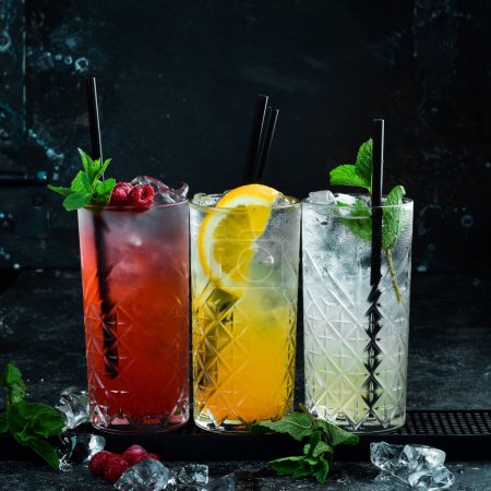 Photo pour Ensemble de cocktails colorés. Un ensemble de limonades. Comptoir de bar avec boissons. Bannière. Sur fond noir. - image libre de droit