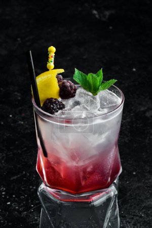 Téléchargez les photos : Cocktail avec liqueur de mûre et zeste de citron dans un verre. Menu bar. - en image libre de droit