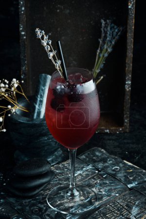 Photo for Cocktail. Alcoholic cocktail with blackberry liqueur and lavender flowers in a glass. Bar menu. - Royalty Free Image