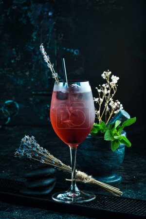 Photo for Cocktail. Alcoholic cocktail with blackberry liqueur and lavender flowers in a glass. Bar menu. - Royalty Free Image