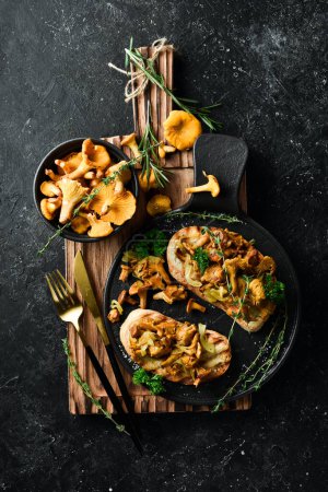 Photo for Bruschetta with chanterelle mushrooms and onions. On a stone plate. Free space for text. - Royalty Free Image