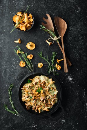 Photo for Cooked chanterelle mushrooms in a cream sauce, in a pan on the kitchen table. Top view. Free space for text. - Royalty Free Image