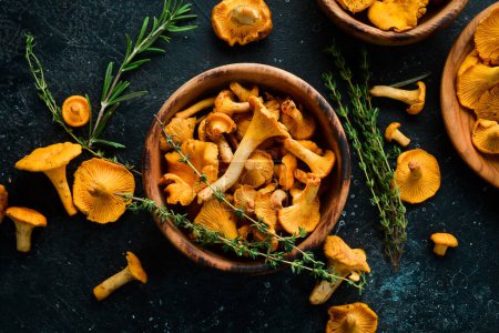 Photo for Chanterelle mushrooms in a bowl. Organic forest food. Top view. On a stone background. - Royalty Free Image