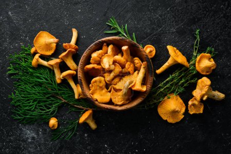 Photo for Chanterelle mushrooms in a bowl. Organic forest food. Top view. On a stone background. - Royalty Free Image