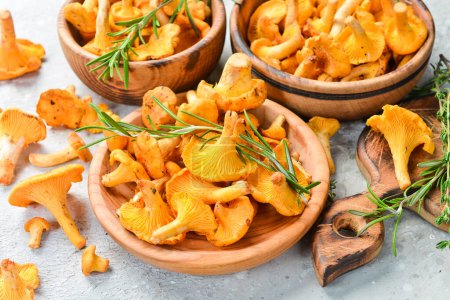 Photo for Raw fresh chanterelle mushrooms in a bowl. Organic forest food. Side view. On a stone background. - Royalty Free Image