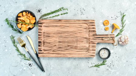 Photo for Cooking concept. Wooden kitchen board on a gray stone background. Top view. Free space for your text. - Royalty Free Image