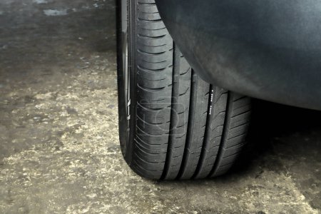 pneu de la roue arrière gauche d'une vieille voiture enregistrée dans le garage