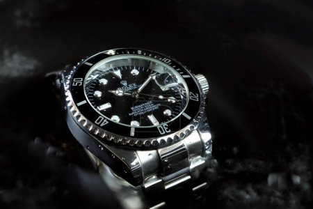 Photo for Rolex vintage wristwatch ceramic bezel model black oyster perpetual submariner date 39 mm display in water background to show water resistant capacity in watch expo festival - Royalty Free Image