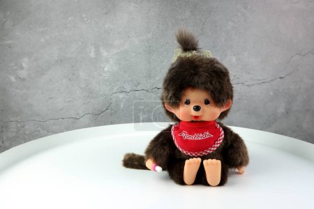 Téléchargez les photos : A popular classic doll toy , Monchichi or Monchhichi , Japanese cute monkey fur doll display on white table with white wall background in souvenir tourist shop in Japan - en image libre de droit