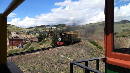 Photo for Steam Engine Train Cripple Creek CO features a steam locomotive coming toward the viewer with people aboard taking a tour of Cripple Creek Colorado near the Victor Gold Mine - Royalty Free Image