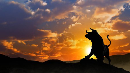 Photo for Stock Market Bull Silhouette at Sunrise features the silhouette of the stock market bull on a hill with a sunrise behind and mist at its feet. - Royalty Free Image