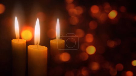 Photo for Candles in the Christmas Lights features three holiday candles flickering in an atmosphere of floating diffused lights, Not A.I. generated. - Royalty Free Image