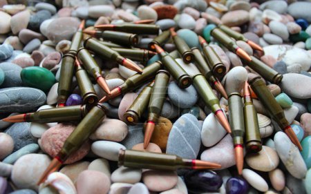 Foto de Small coastal stones with randomly scattered live ammunition - Imagen libre de derechos