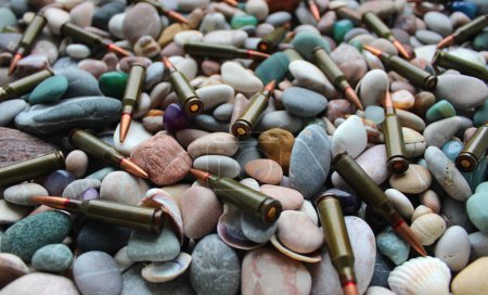 Téléchargez les photos : Bullets Scattered On A Pebble Stones Texture Background Stock Photo - en image libre de droit