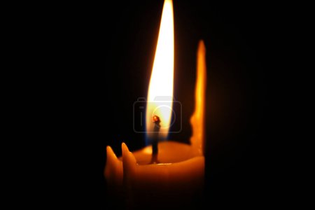 Foto de Fire around the wick of a melted wax candle closeup. Concept for smartphone wallpaper or vertical mourning card - Imagen libre de derechos