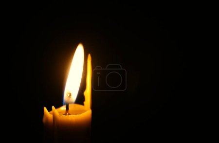 Téléchargez les photos : The top of a swollen candle with a staggering fire on the left side of the image. Concept for condolences card - en image libre de droit