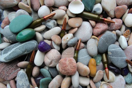 Foto de Closeup of unitary cartridges partially covered with colored smooth stones - Imagen libre de derechos