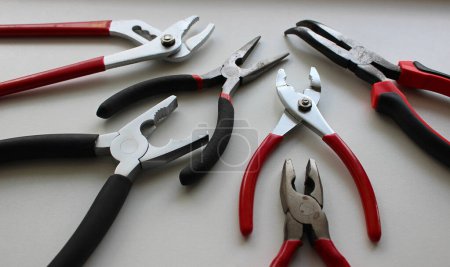 Photo for Set Of Different Types Of Mechanics Pliers On White Surface Detailed Stock Photo - Royalty Free Image