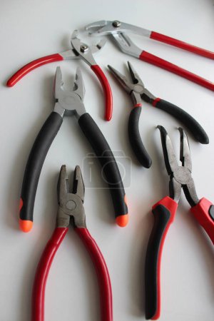 Photo for Vertical Stock Photo Of Slip Joint Pliers, Groove Pliers, Needle Nose Pliers And Linesman Pliers With Opened Jaws - Royalty Free Image