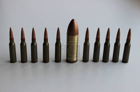 Foto de Foto conceptual sobre el tema de la diversidad con una bala grande en una fila de balas idénticas más pequeñas - Imagen libre de derechos
