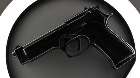 Photo for Automatic Handgun Inside Circle Of Light With Barrel Down - Royalty Free Image